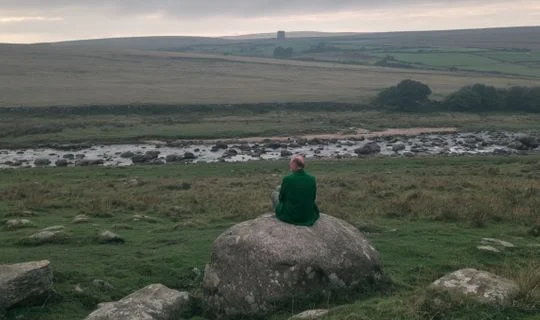 a man on a rock in the wilderness in the UK 
