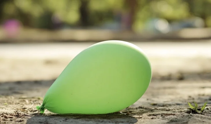 a green balloon on the ground 